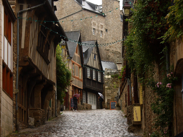 Cobblestone street clock tower person free wallpaper for desktop - medium preview image