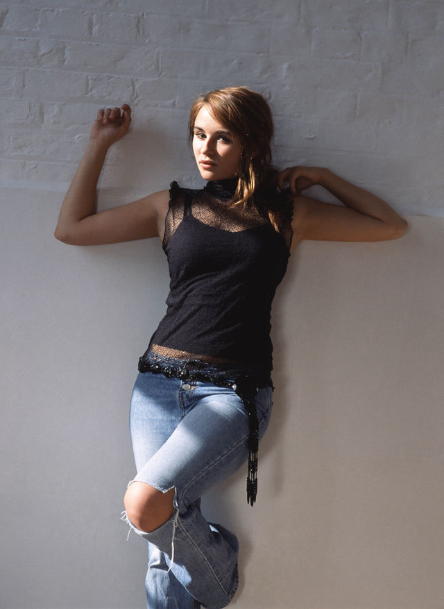 Woman leaning wall arms behind free wallpaper for mobile - medium preview image