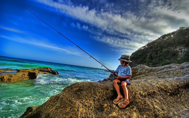 Man sitting rock fishing ocean free wallpaper for desktop - medium preview image