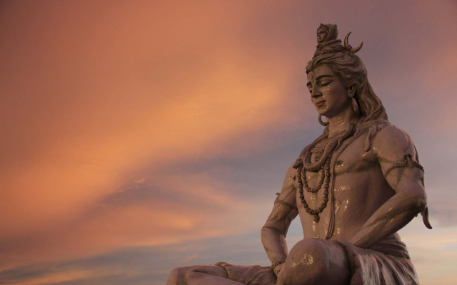 Statue man sitting rock sky free wallpaper for desktop - medium preview image