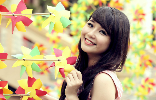 Woman holding pinwheels smiling colorful free wallpaper for desktop - medium preview image