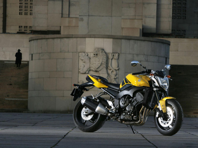Yellow motorcycle parked building statue free wallpaper for desktop - medium preview image