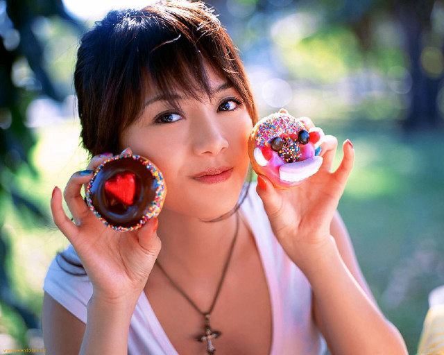 Woman holding two donuts with free wallpaper for desktop - medium preview image