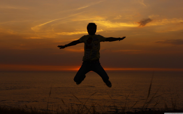 Man jumping sunset ocean arms free wallpaper for desktop - medium preview image