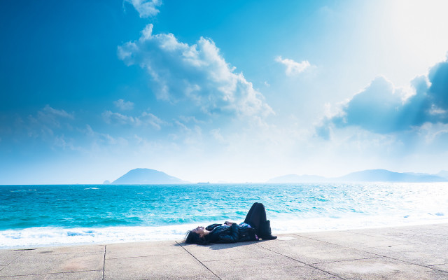 Person laying ground ocean sky free wallpaper for desktop - medium preview image