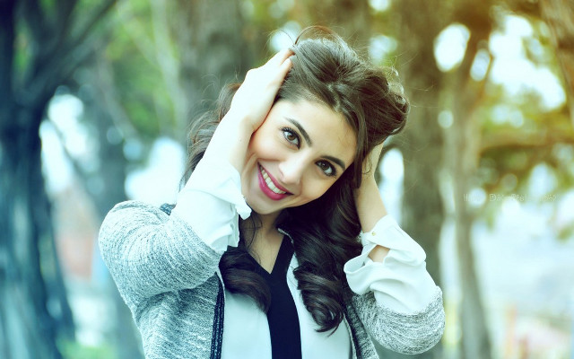 Smiling woman holding hair tree free wallpaper for desktop - medium preview image