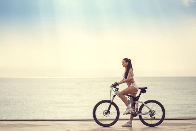 Woman biking ocean sunny day free wallpaper for desktop - medium preview image