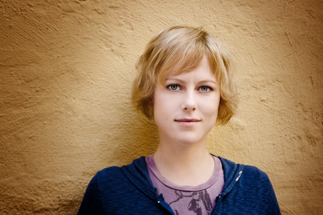 Woman yellow wall blue jacket free wallpaper for desktop - medium preview image