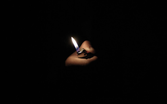 Person holding lighter dark background #2 free wallpaper for desktop - medium preview image