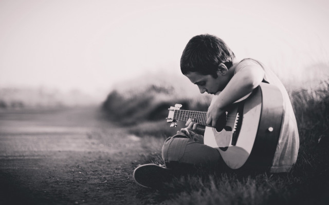 Young boy grass playing guitar free wallpaper for desktop - medium preview image