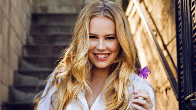 Woman holding purple flower smiling free wallpaper for desktop - medium preview image