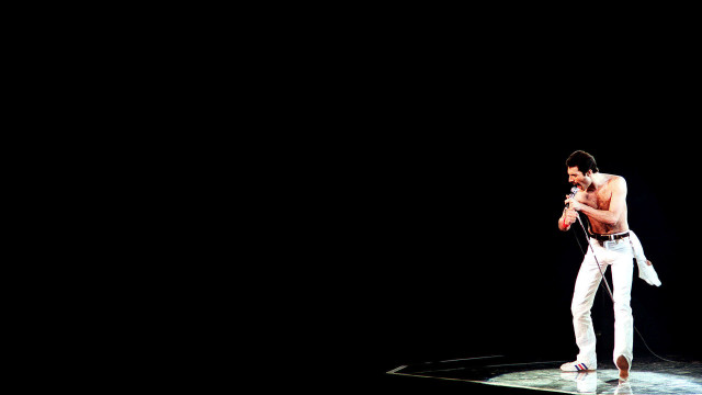 Man standing stage microphone hand free wallpaper for desktop - medium preview image