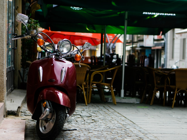 Red scooter cobblestone street restaurant free wallpaper for desktop - medium preview image