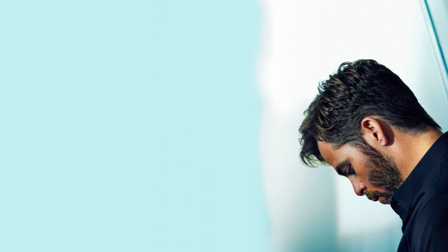 Bearded man black shirt leaning free wallpaper for desktop - medium preview image