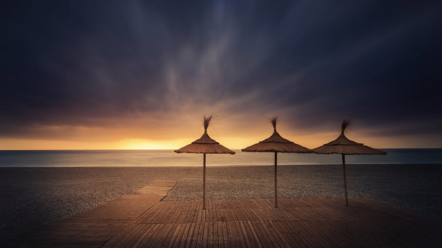 Umbrellas pier ocean sunset cloudy free wallpaper for desktop - medium preview image