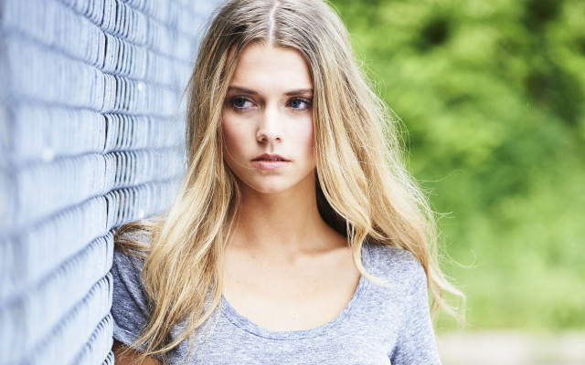 Woman leaning wall serious blonde free wallpaper for desktop - medium preview image