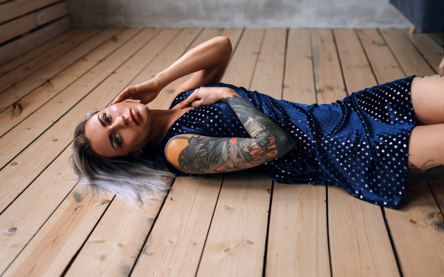 Tattooed woman laying on wooden free wallpaper for desktop - medium preview image