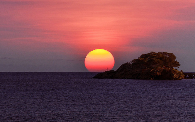 Sunset island person rock mountain free wallpaper for desktop - medium preview image