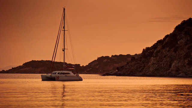 Sailboat rocky shore sunset mountain free wallpaper for desktop - medium preview image