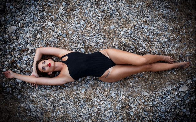 Woman black swimsuit rocky laying free wallpaper for desktop - medium preview image