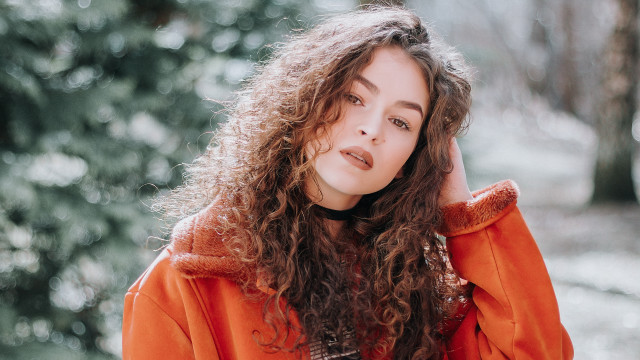 Woman curlyhair orangejacket woods portrait free wallpaper for desktop - medium preview image