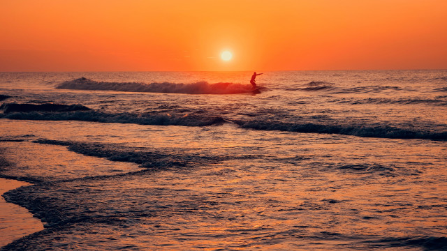 Surfing wave ocean sunset cloudy free wallpaper for desktop - medium preview image