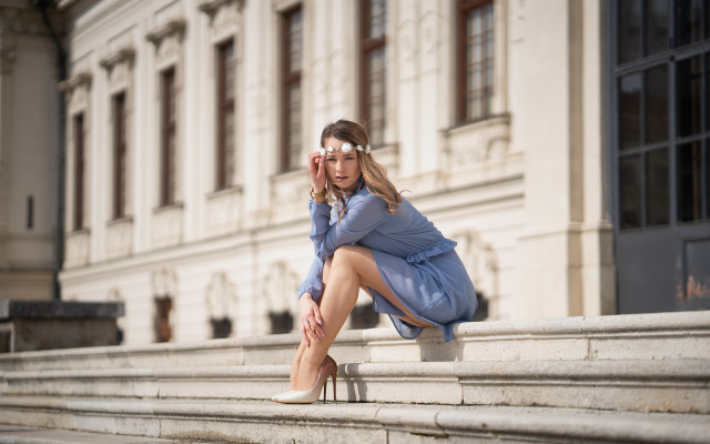 Woman bluecoat sitting architecture blurry free wallpaper for desktop - medium preview image