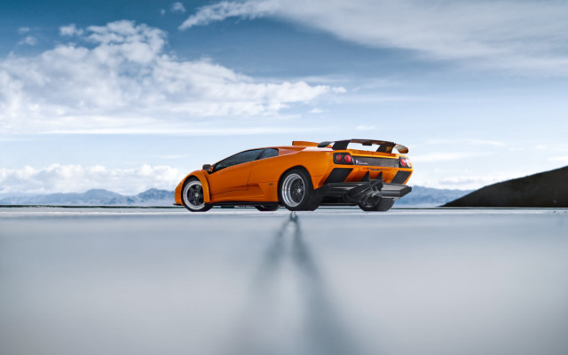 Orange sports car mountains blue free wallpaper for desktop - medium preview image