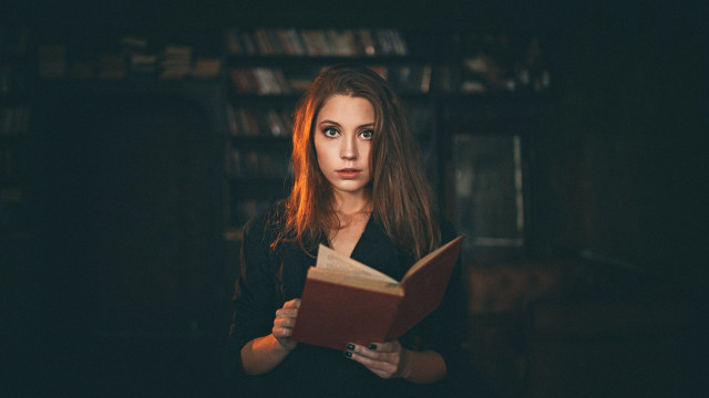 Woman holding book serious portrait free wallpaper for desktop - medium preview image