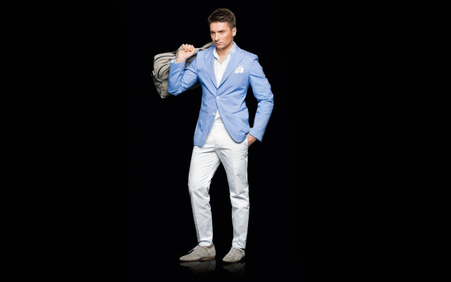 Man bluejacket whitepants holdingjacket camera free wallpaper for desktop - medium preview image