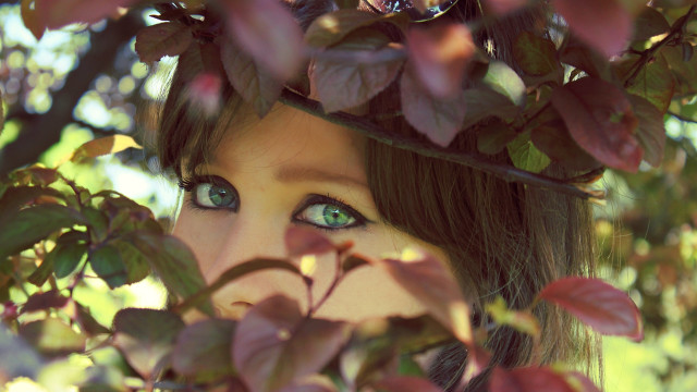 Woman green eyes hiding behind free wallpaper for desktop - medium preview image