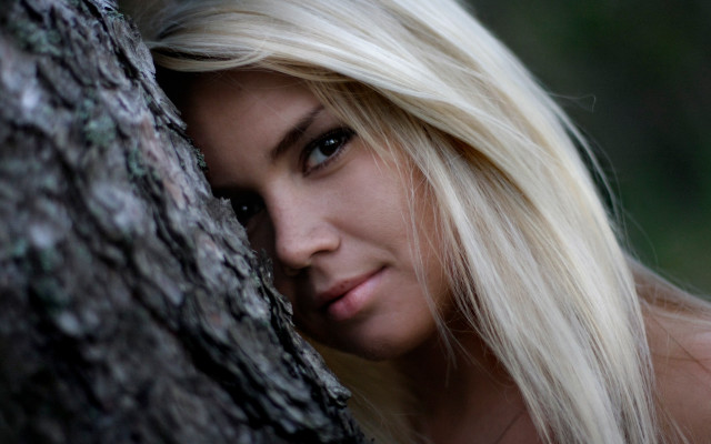 Blonde woman leaning against tree free wallpaper for desktop - medium preview image