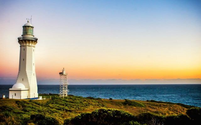 Lighthouse grassy hill ocean sunset free wallpaper for desktop - medium preview image