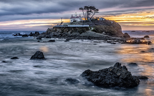Lighthouse rocky shore sunset ocean free wallpaper for desktop - medium preview image