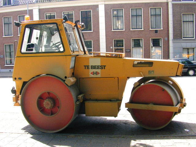 Yellow tractor parked street building free wallpaper for desktop - medium preview image