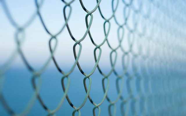 Chain link fence ocean blurry free wallpaper for desktop - medium preview image