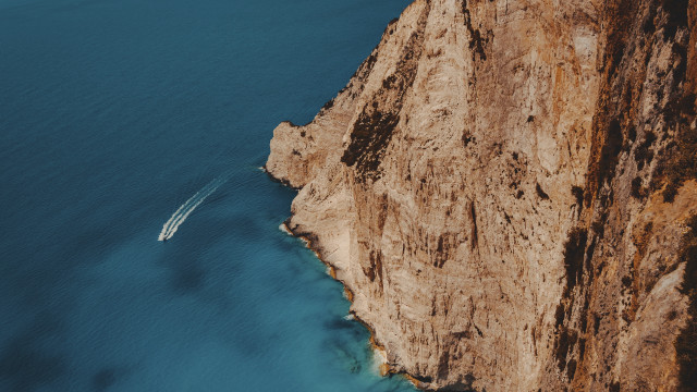 Boat cliff water cinematic photorealism free wallpaper for desktop - medium preview image