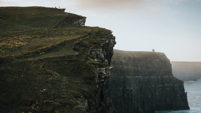 Cliff overlooking ocean lighthouse figure free wallpaper for desktop - medium preview image