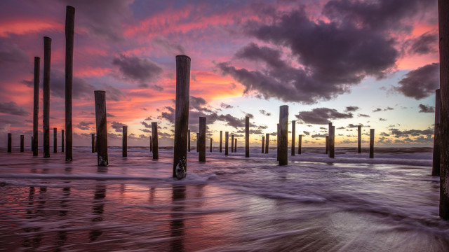 Sunset pier waves poles cityscape free wallpaper for desktop - medium preview image