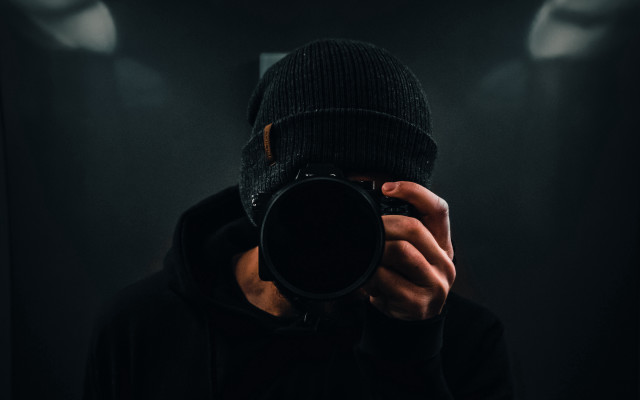 Man holding camera dark room free wallpaper for desktop - medium preview image