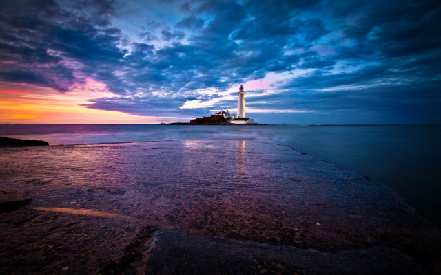 Lighthouse rocky shore sunset clouds free wallpaper for desktop - medium preview image