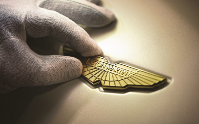 Gloved person gold emblem car free wallpaper for desktop - medium preview image
