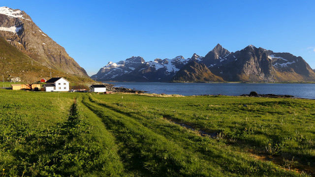 Grassy field house mountains water free wallpaper for desktop - medium preview image