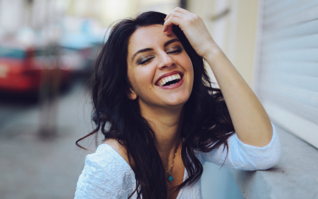 Smiling woman leaning wall jewelry free wallpaper for desktop - medium preview image