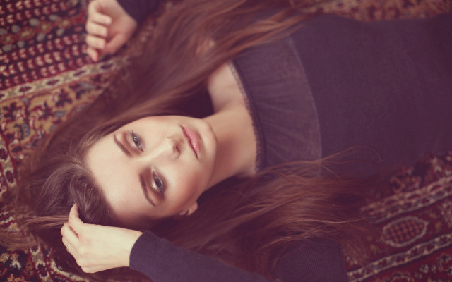 Woman laying rug blurry portrait free wallpaper for desktop - medium preview image