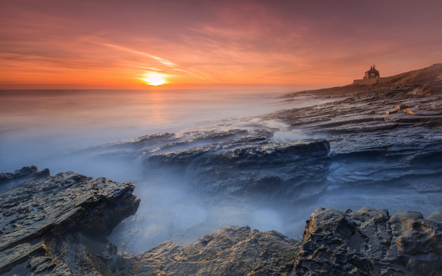 Rocky beach lighthouse sunset foggy free wallpaper for desktop - medium preview image