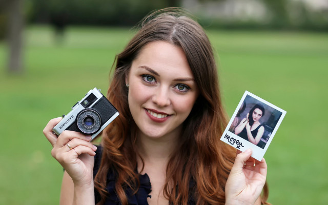 Woman holding polaroids camera portrait free wallpaper for desktop - medium preview image