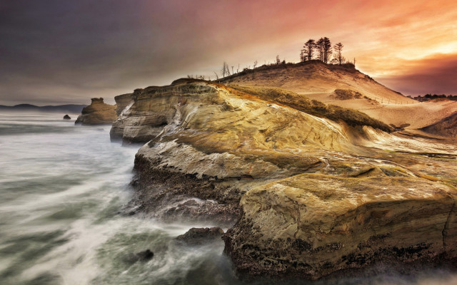 Rocky cliff lighthouse sunset cloudy free wallpaper for desktop - medium preview image