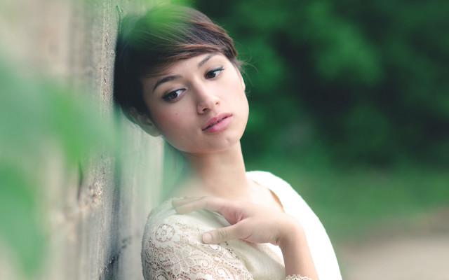 Woman leaning wall serious portrait free wallpaper for desktop - medium preview image