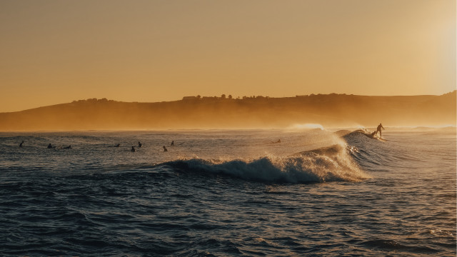 Surfing group wave ocean sunset free wallpaper for desktop - medium preview image